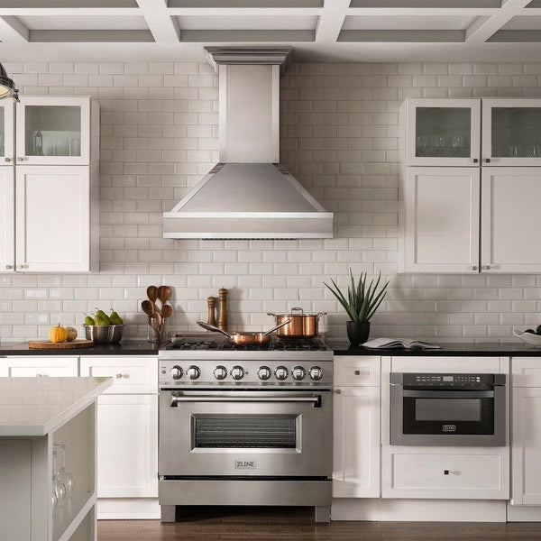 ZLINE Designer Series Wall Mount Range Hood in Fingerprint Resistant Stainless Steel with Mirror Accents (655MR) in a luxury compact kitchen with matching range and microwave, front.