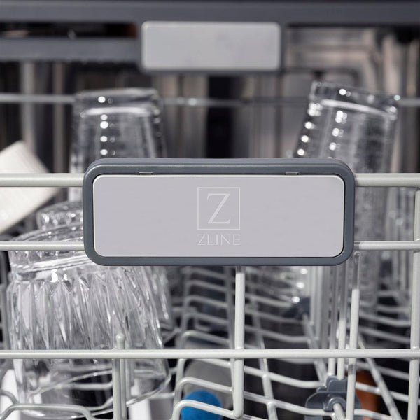 ZLINE Autograph Edition 24 in. Monument Series 3rd Rack Top Touch Control Tall Tub Dishwasher in Black Matte with Champagne Bronze Handle, 45dBa (DWMTZ-BLM-24-CB) close-up, ZLINE logo on dish rack.