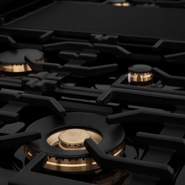 ZLINE brass burners on black porcelain cooktop with cast-iron grates.
