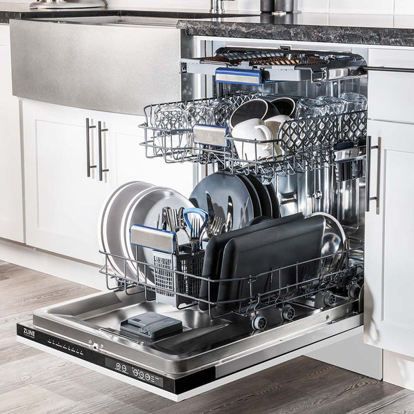 ZLINE 24" Tallac Series 3rd Rack Dishwasher with White Matte Panel and Traditional Handle, 51dBa (DWV-WM-24) in a luxury kitchen from side, open with dishes loaded on all dish racks.