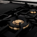 ZLINE brass burners on black porcelain cooktop with cast-iron grates.