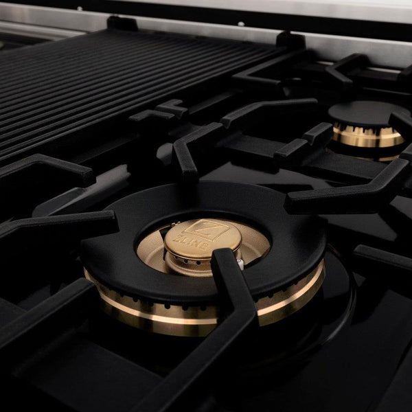 ZLINE brass burners on black porcelain cooktop with cast-iron grates.