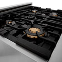 ZLINE brass burners on black porcelain cooktop with cast-iron grates.