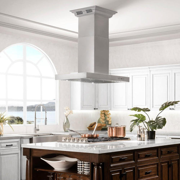ZLINE Island Mount Range Hood in Stainless Steel with Built-in ZLINE CrownSound Bluetooth Speakers (KE2iCRN-BT) lifestyle image from side in a luxury kitchen.