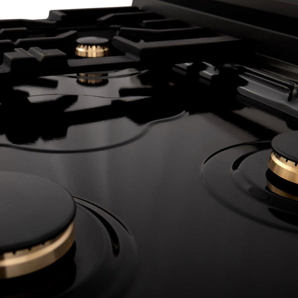 ZLINE brass burners on black porcelain cooktop with no grates.